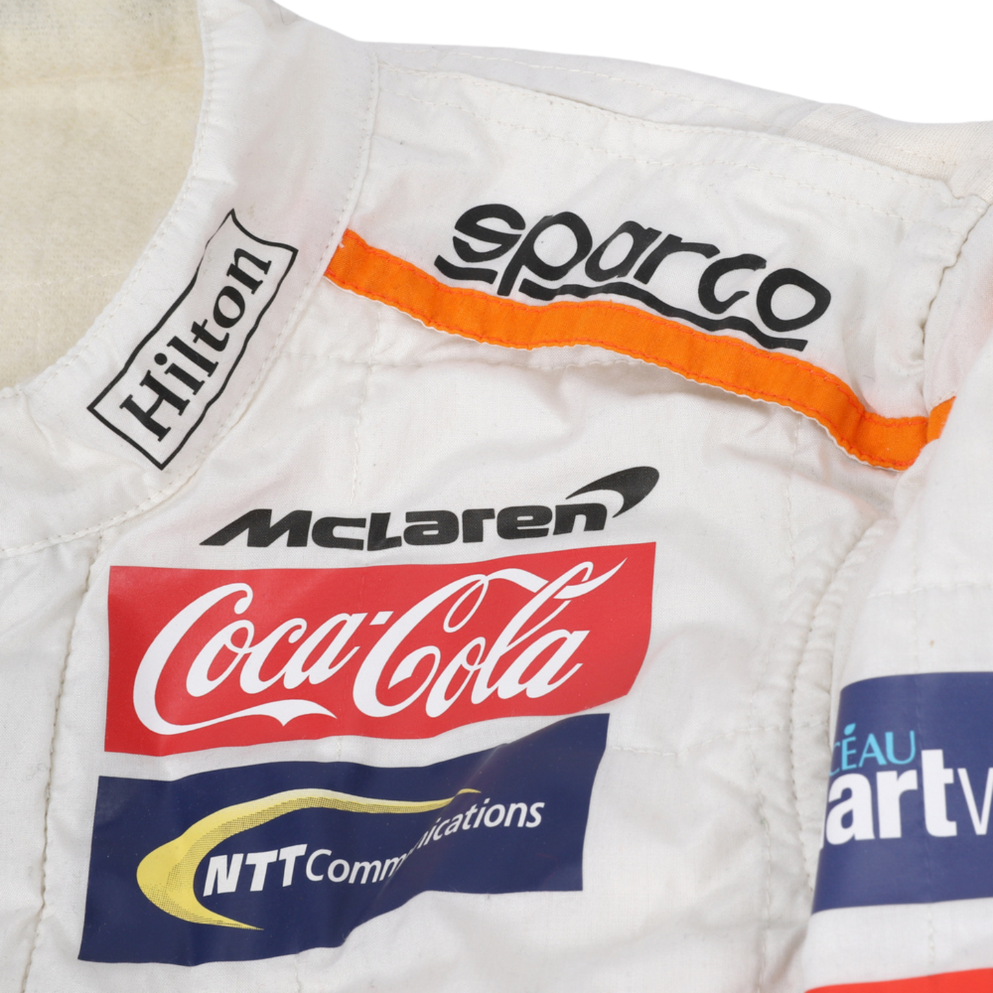 Close-up of the shoulder area of Fernando Alonso’s 2018 F1 racing suit, showing embroidered sponsor logos and the breathable fabric for improved performance during races.