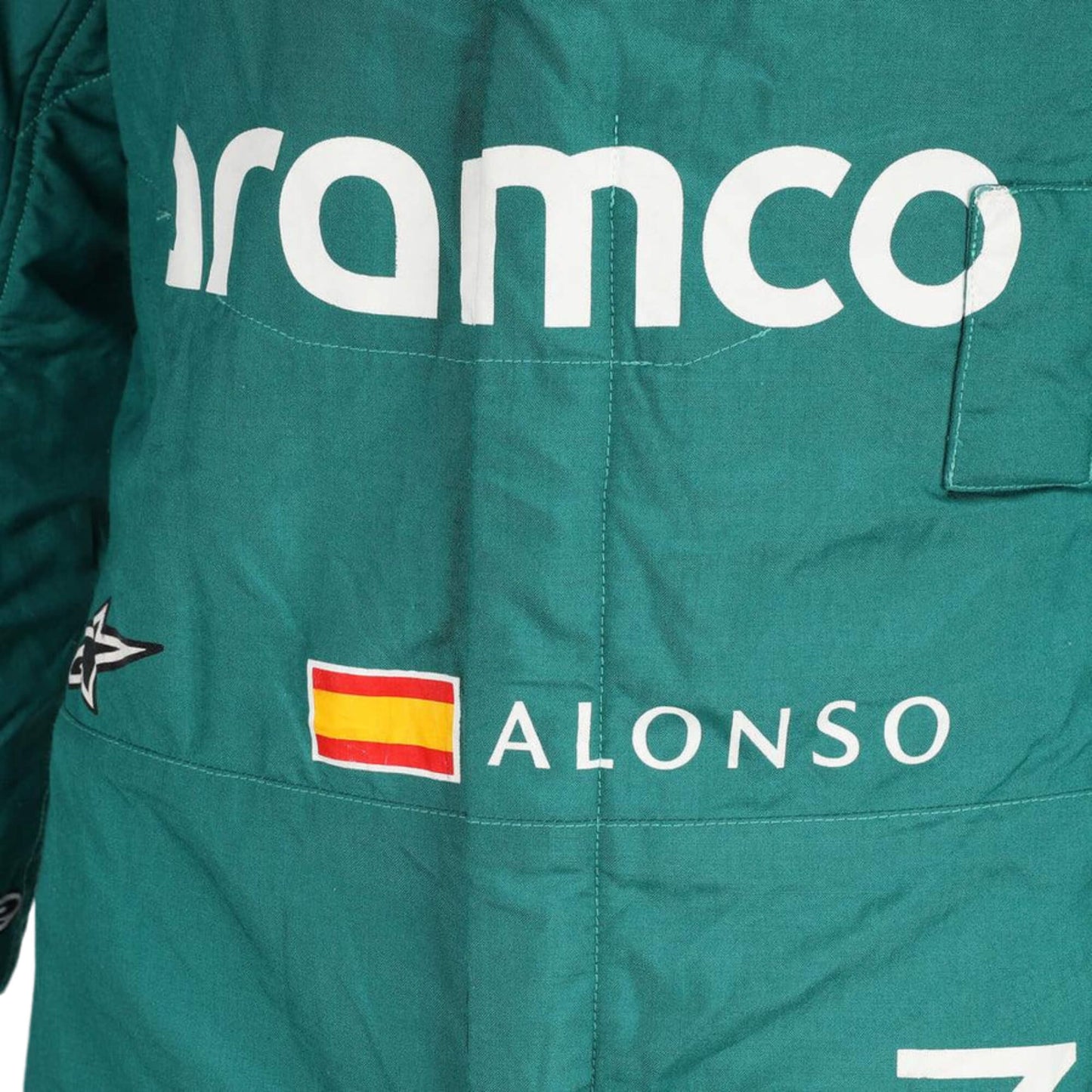 Close-up of the fabric and stitching on Fernando Alonso’s 2023 F1 racing suit, capturing the high-quality material and detailed sponsor branding, designed for durability and race-ready functionality.