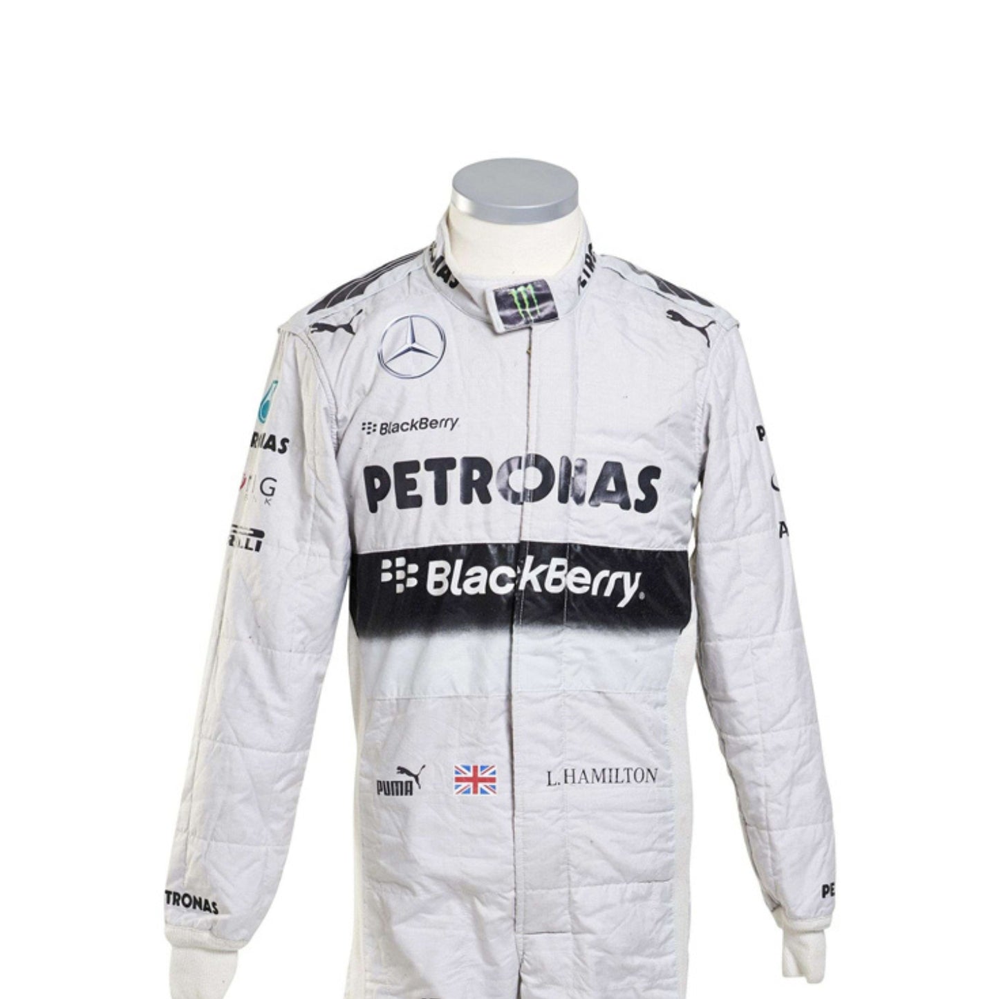 Close-up of Lewis Hamilton’s 2014 racing suit showing intricate stitching, sponsor branding, and iconic white-teal color scheme used throughout the championship.