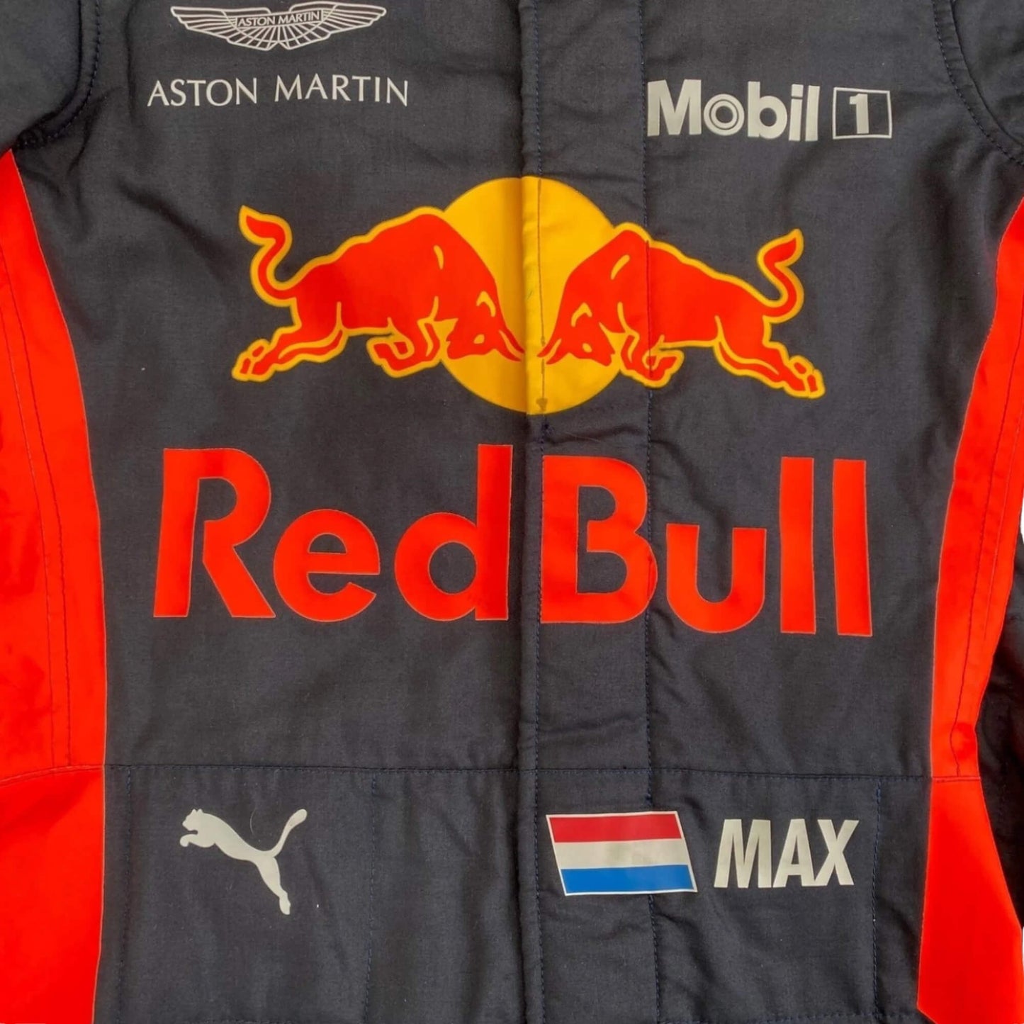 Close-up of Max Verstappen 2018 F1 racing suit chest area, logo embroidery and textured stitching detail.