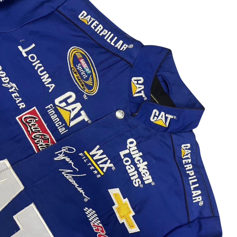 Close-up of the embroidered Caterpillar logo and sponsor patches on the cotton-padded F1 Motorsports jacket. The detailed stitching on resilient fabric emphasizes the jacket’s robust design, blending warmth and style for Caterpillar and F1 enthusiasts.