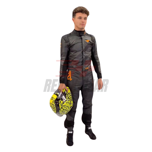 Front view of the 2025 McLaren F1 livery reveal racing costume worn by Lando Norris featuring a sleek matte black base with bold orange logos and driver initials (LN4) in neon orange.