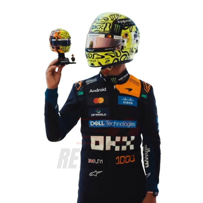 Close up View of Lando Norris wearing a McLaren Monaco GP F1 racing suit, holding a helmet with sponsor logos - Revex Gear