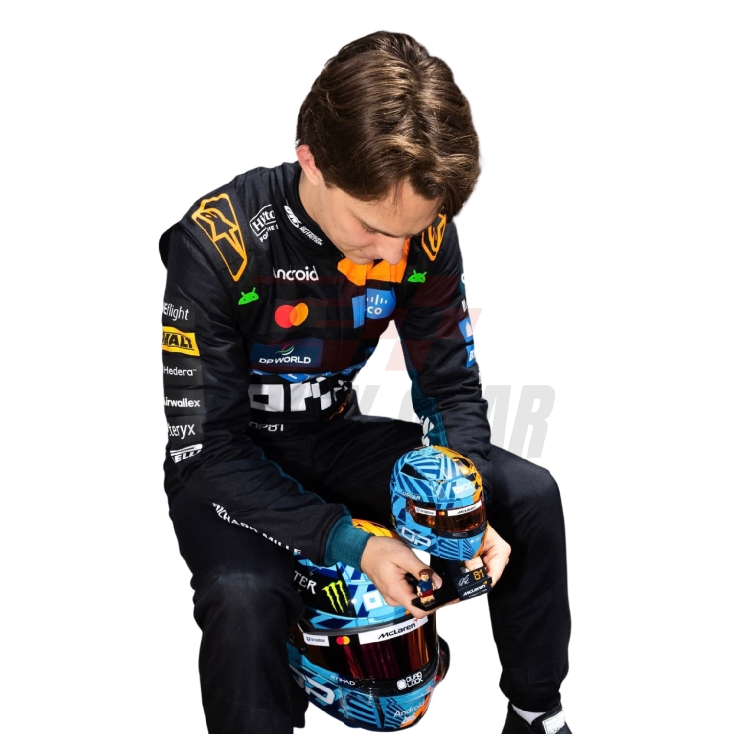 Sitting View of Oscar Piastri wearing a McLaren Monaco GP F1 racing suit holding a helmet with sponsor logos - Revex Gear