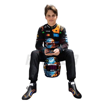 Oscar Piastri wearing a McLaren Monaco GP F1 racing suit, sitting on a helmet with visible branding - Revex Gear