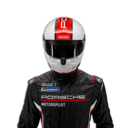 Black Porsche Motorsport racing suit with red and white stripes, shown on a model wearing a white racing helmet and black gloves