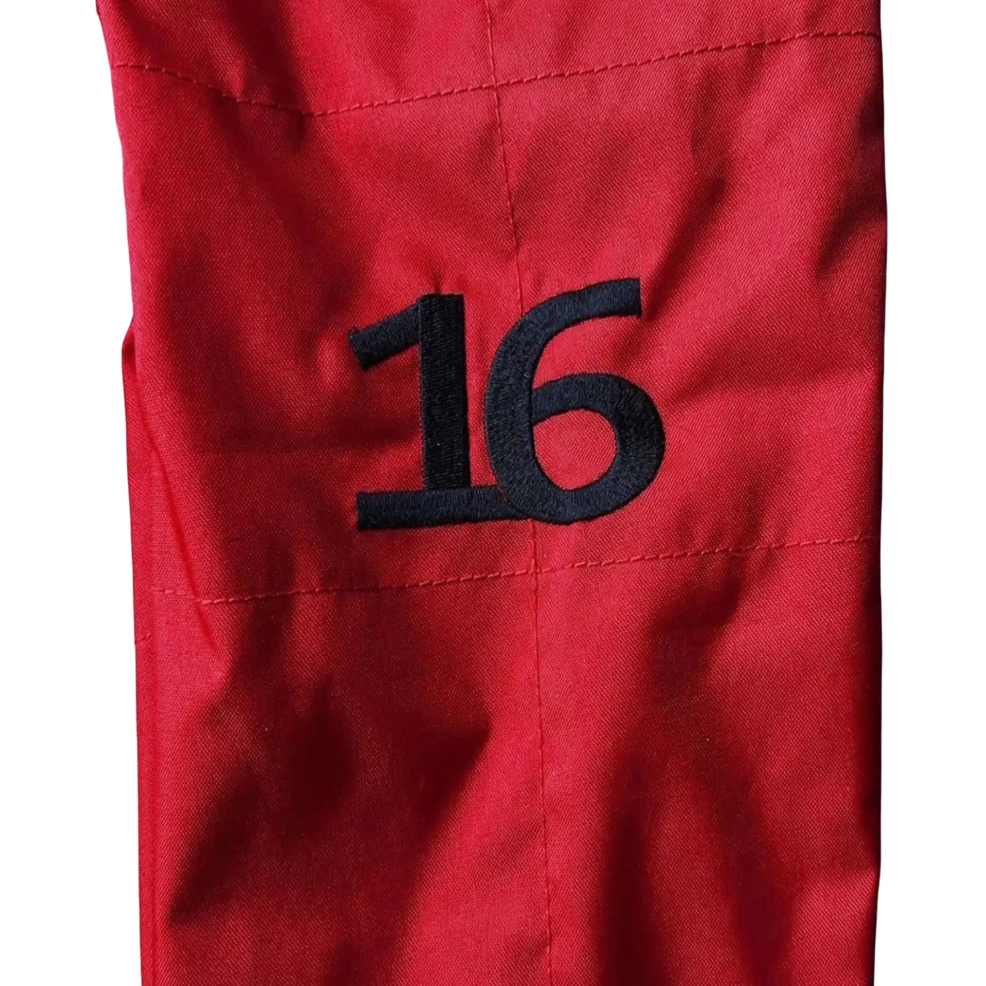 Close-up of the aim of the 2022 Ferrari race suit, showing sponsor embroidery logo and sturdy 2-layer fabric details.