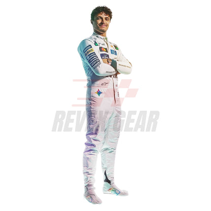 A full-body studio photo of Lando Norris wearing a white McLaren 2026 British GP F1 racing suit with multiple sponsor logos and colorful patches, standing with arms crossed against a plain white background. A faint REVEX GEAR watermark is visible across the center.